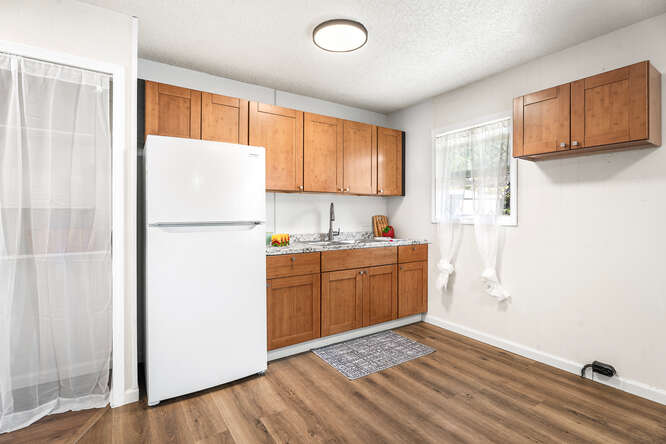 75-164 Lunapule Road Kailua-Kona, HI 96740 - Photo 12 of 27 a kitchen with a refrigerator a stove top oven a sink and dishwasher with wooden floor