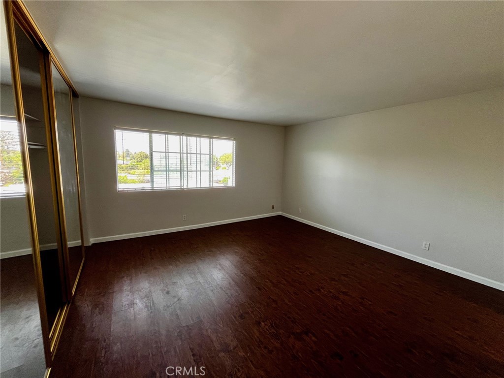 4140 Warner Boulevard, Unit 310 Burbank, CA 91505 - Photo 12 of 18 an empty room with wooden floor and windows