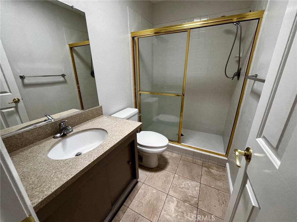 4140 Warner Boulevard, Unit 310 Burbank, CA 91505 - Photo 15 of 18 a bathroom with a granite countertop sink toilet and shower