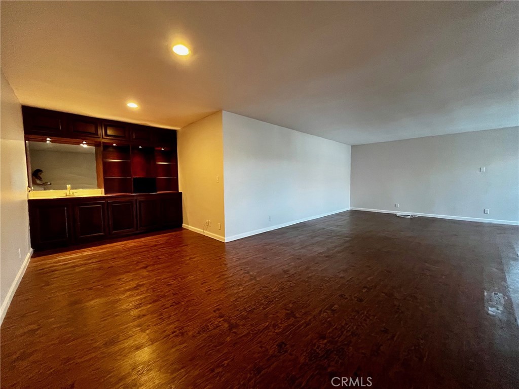 4140 Warner Boulevard, Unit 310 Burbank, CA 91505 - Photo 2 of 18 a view of an empty room with wooden floor and a kitchen