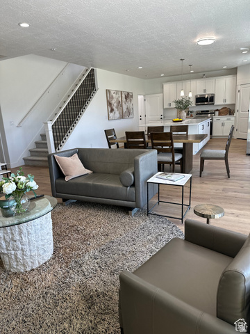 7927 Bristlecone Road, Unit 204 Eagle Mountain, UT 84005 - Photo 5 of 19 Living room featuring light wood-style flooring, recessed lighting, and a textured ceiling