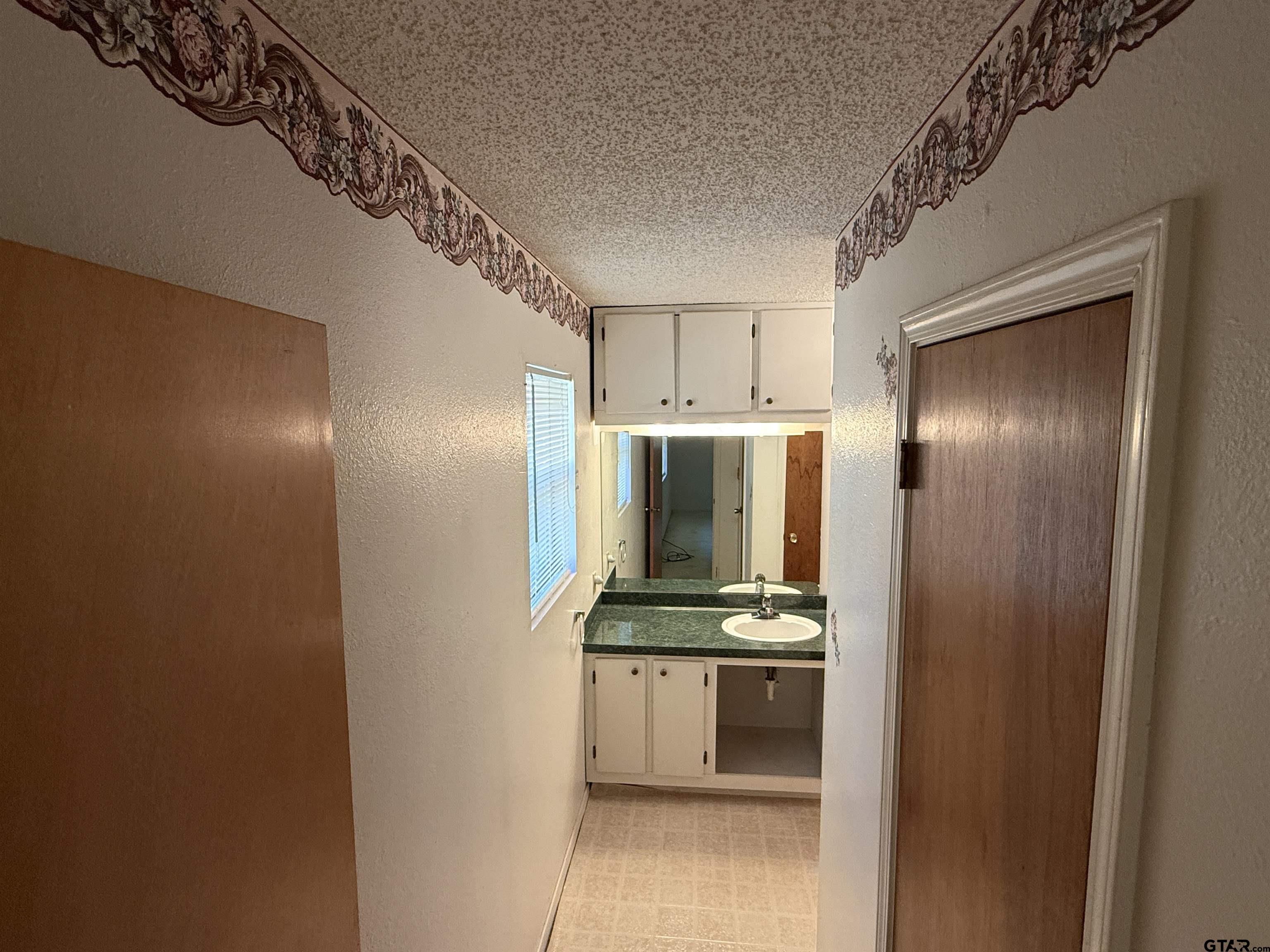 226 Caroline Street Rusk, TX 75785 - Photo 2 of 21 a hallway with sink and white cabinets