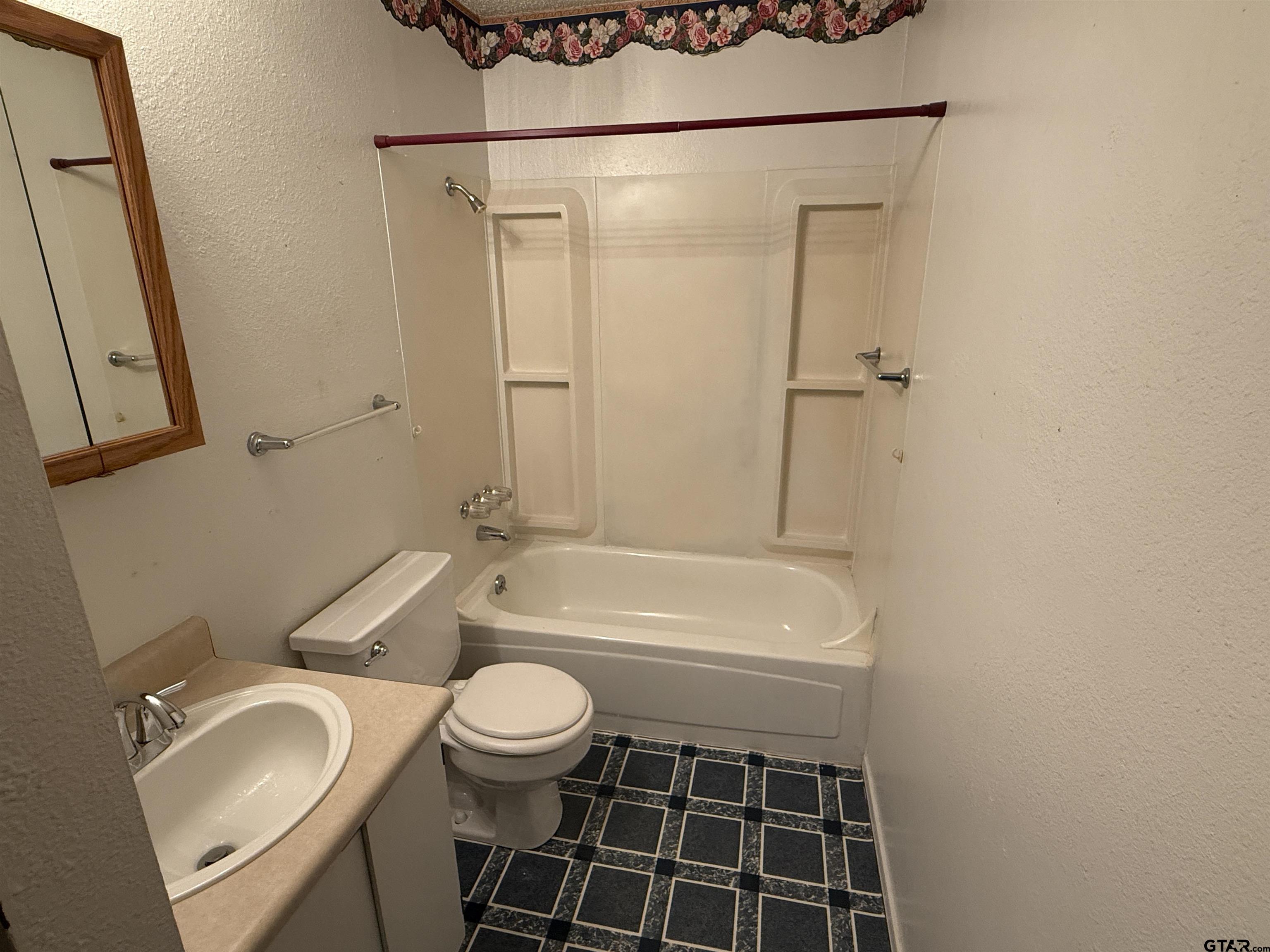 226 Caroline Street Rusk, TX 75785 - Photo 5 of 21 a bathroom with a granite countertop sink toilet a mirror and bathtub
