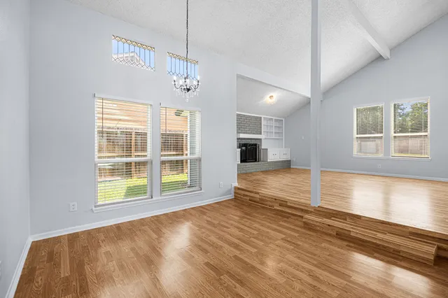 a view of empty room with wooden floor and fireplace