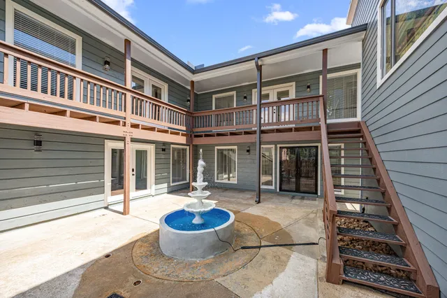 a front view of a building with a fountain and a potted plant