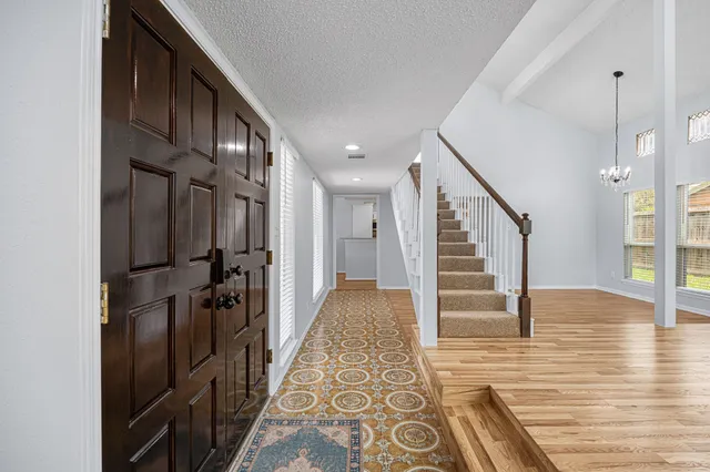 a view of hallway with wooden floor and staircase