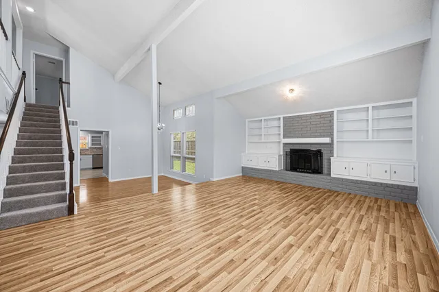 a view of empty room with wooden floor and fireplace