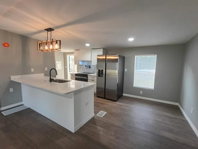 a kitchen with stainless steel appliances a stove refrigerator and microwave