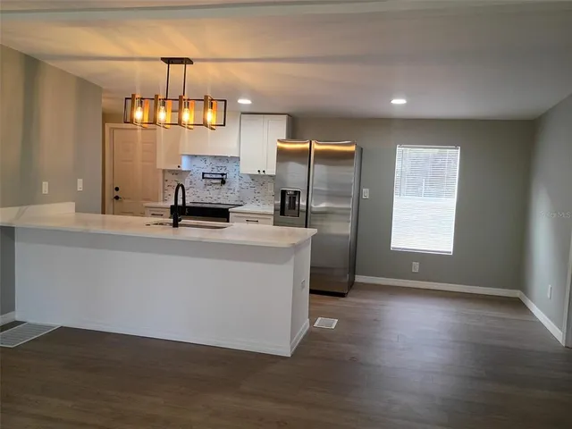 a view wooden floor with kitchen view and wooden floor