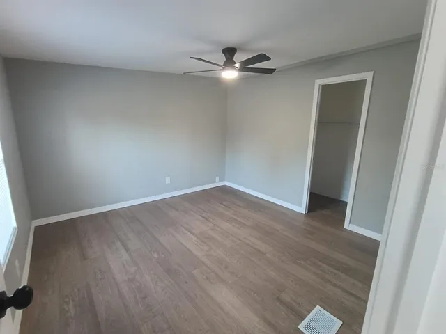 an empty room with wooden floor and window