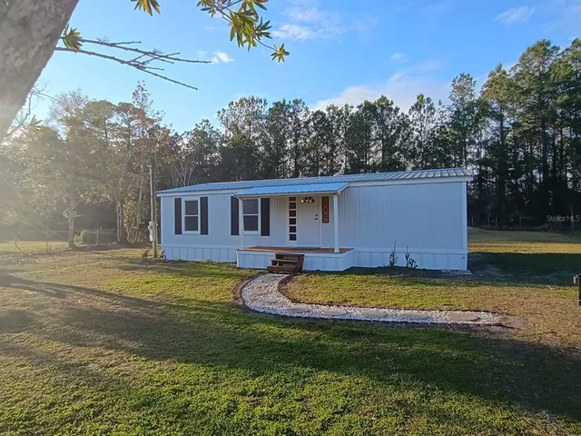 a view of a house with swimming pool and a yard