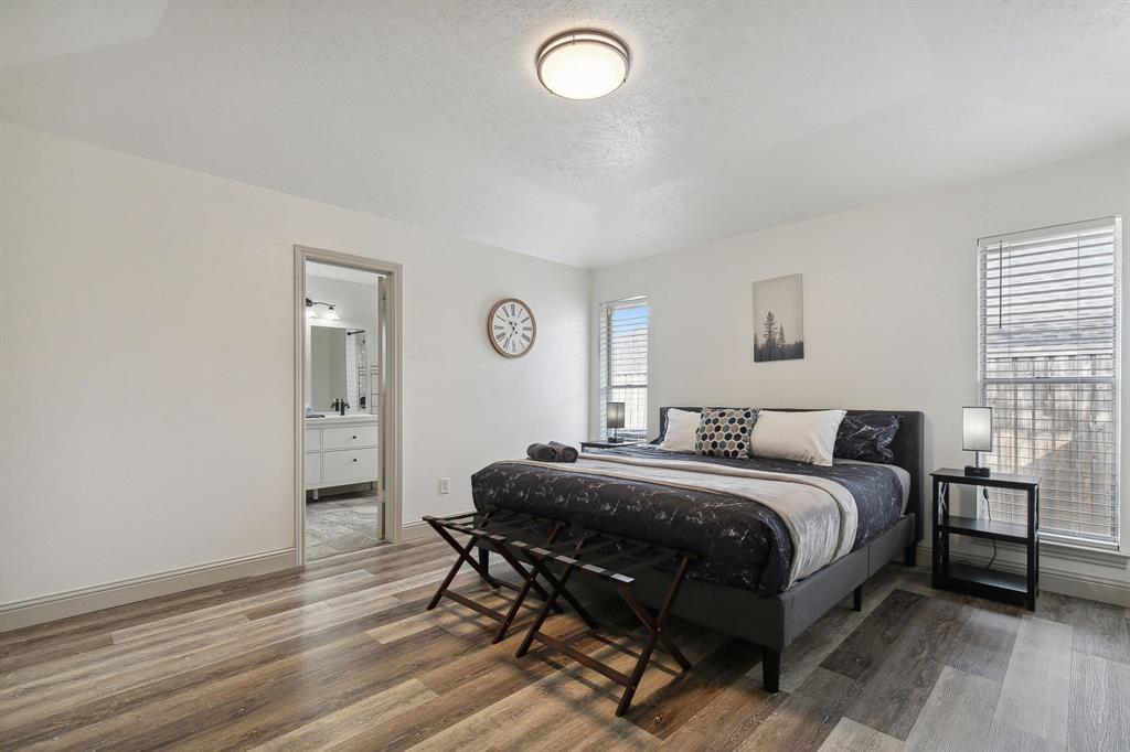 1813 Cross Bend Road Plano, TX 75023 - Photo 23 of 30 a bedroom with a bed and a table