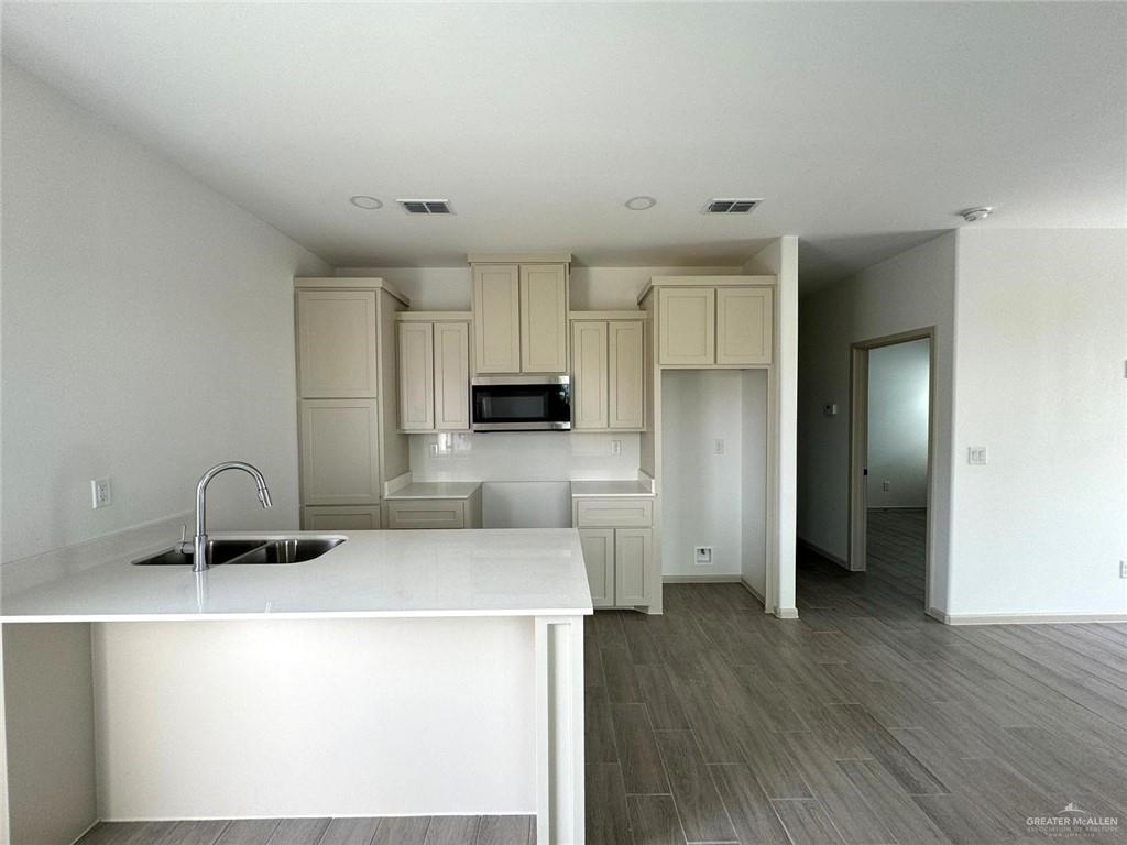 7811 North 58th Street, Unit 3 Mission, TX 78573 - Photo 3 of 11 a kitchen with a sink a stove a refrigerator and cabinets