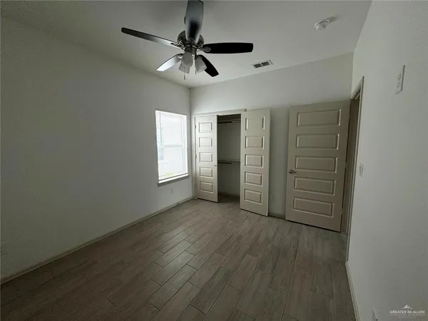 an empty room with closet and windows