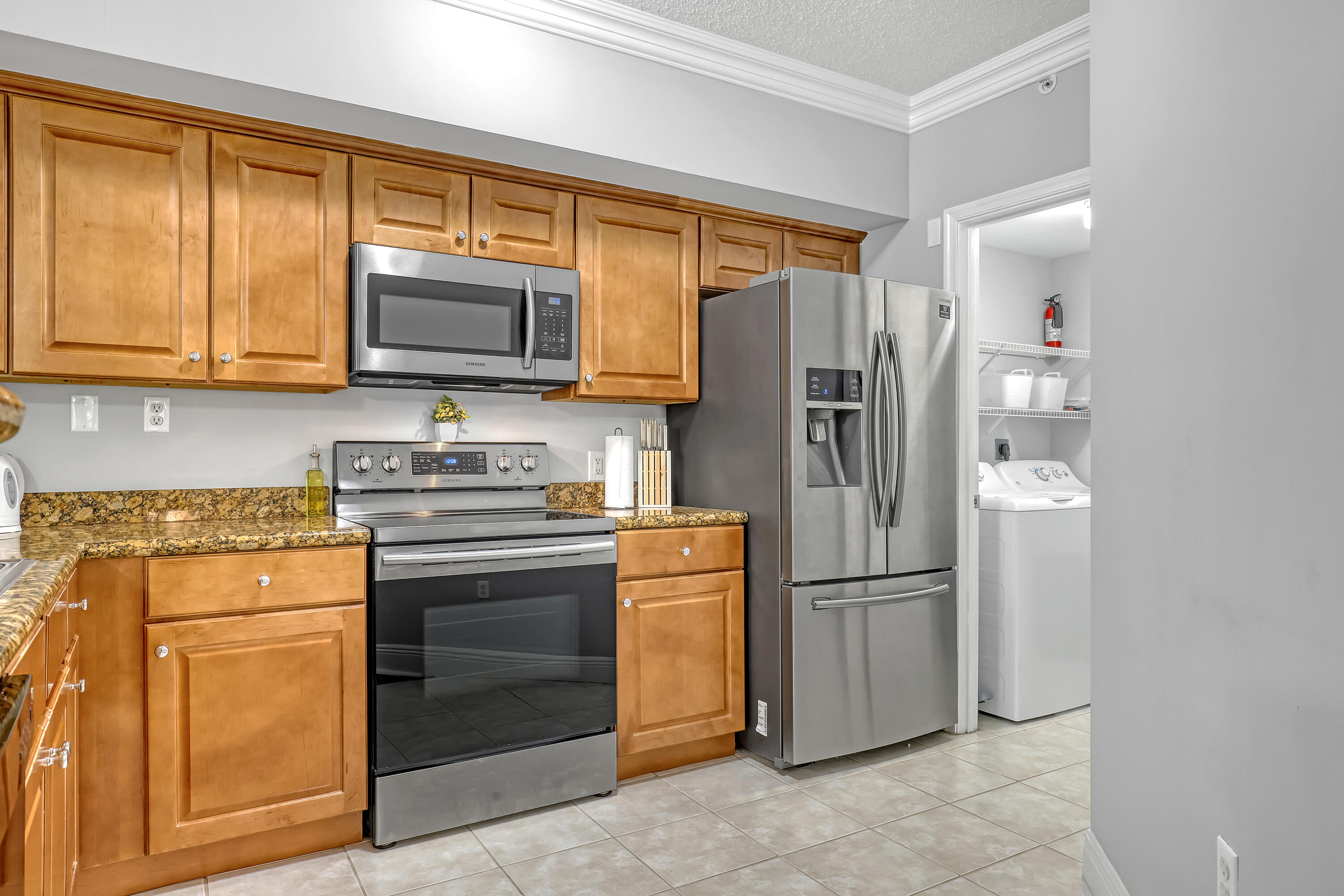 11790 St Andrews Place, Unit 105 Wellington, FL 33414 - Photo 11 of 55 a kitchen with stainless steel appliances granite countertop a refrigerator stove and microwave