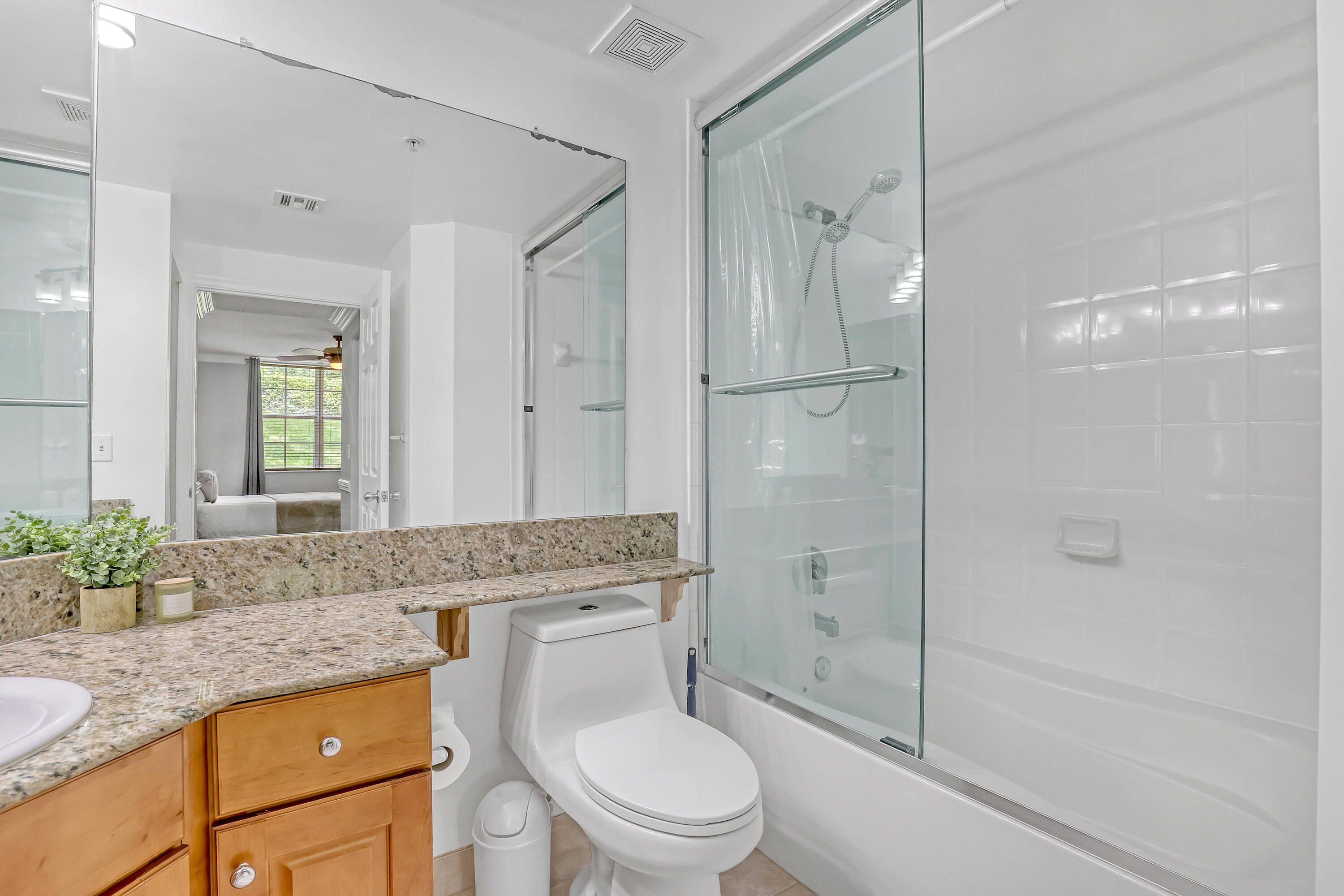 11790 St Andrews Place, Unit 105 Wellington, FL 33414 - Photo 21 of 55 a bathroom with a granite countertop sink a toilet and shower