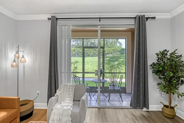 a front view of a house with a yard and potted plants