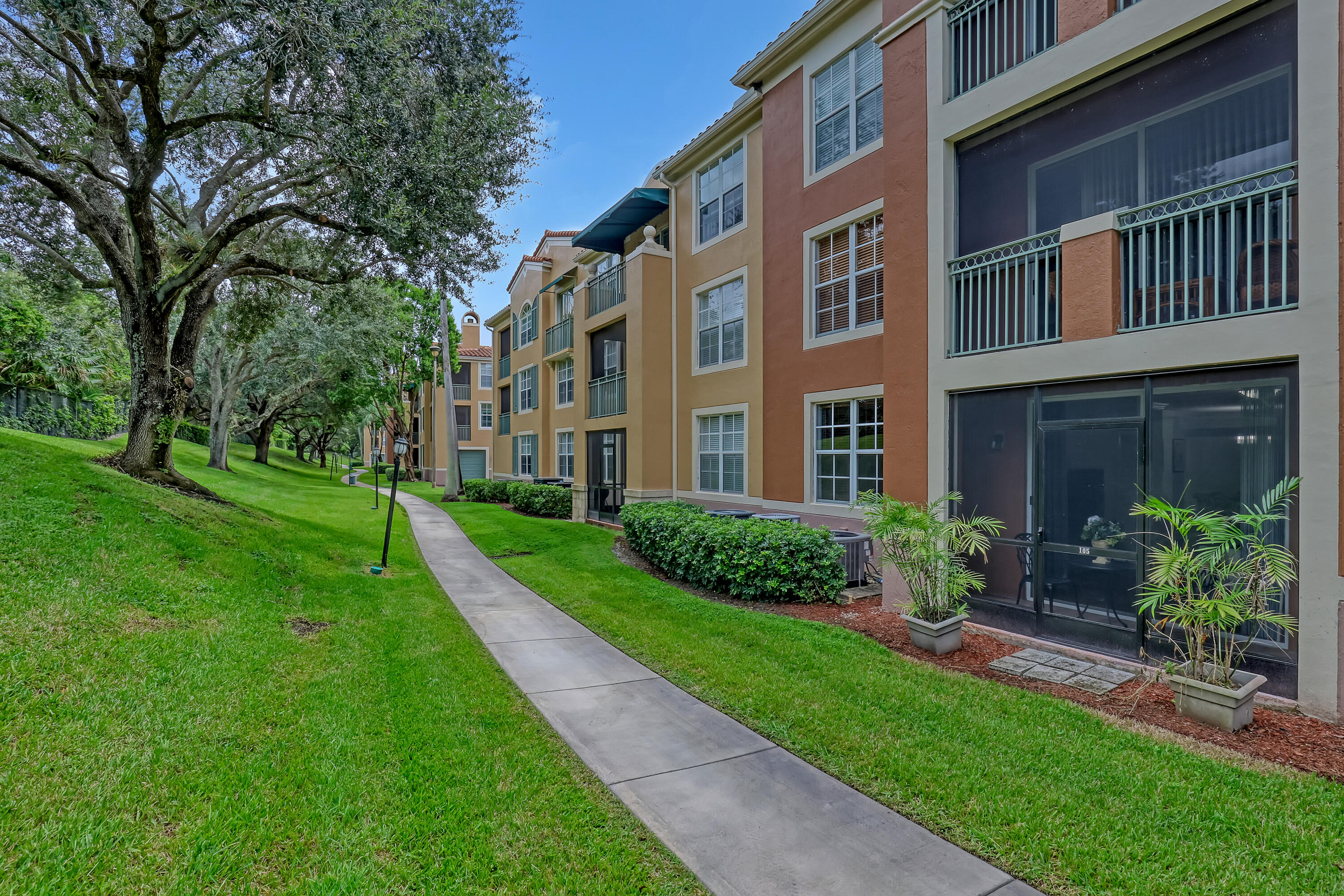11790 St Andrews Place, Unit 105 Wellington, FL 33414 - Photo 33 of 55 a view of a building front with a garden