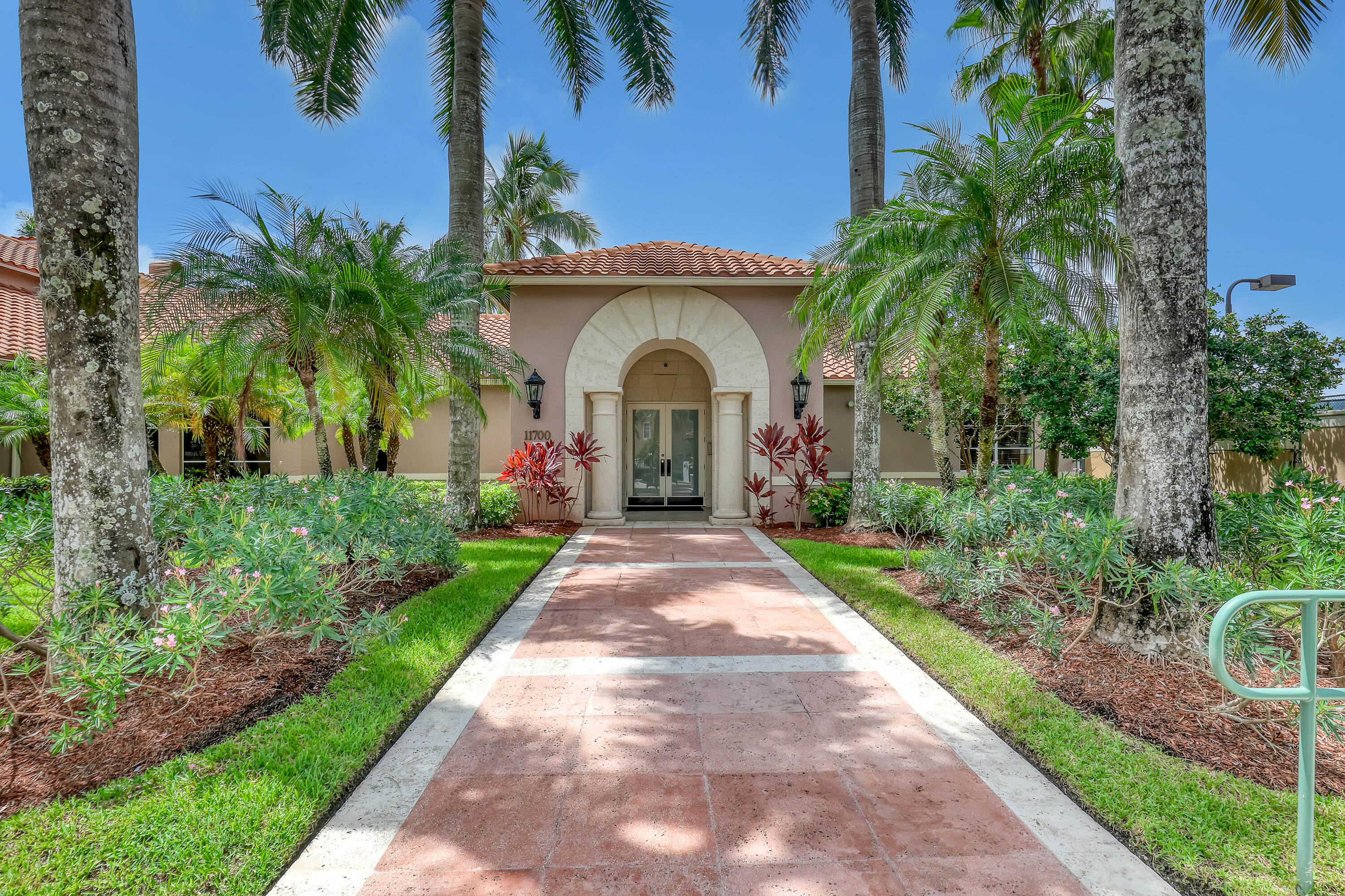 11790 St Andrews Place, Unit 105 Wellington, FL 33414 - Photo 38 of 55 a view of a house with a yard and potted plants