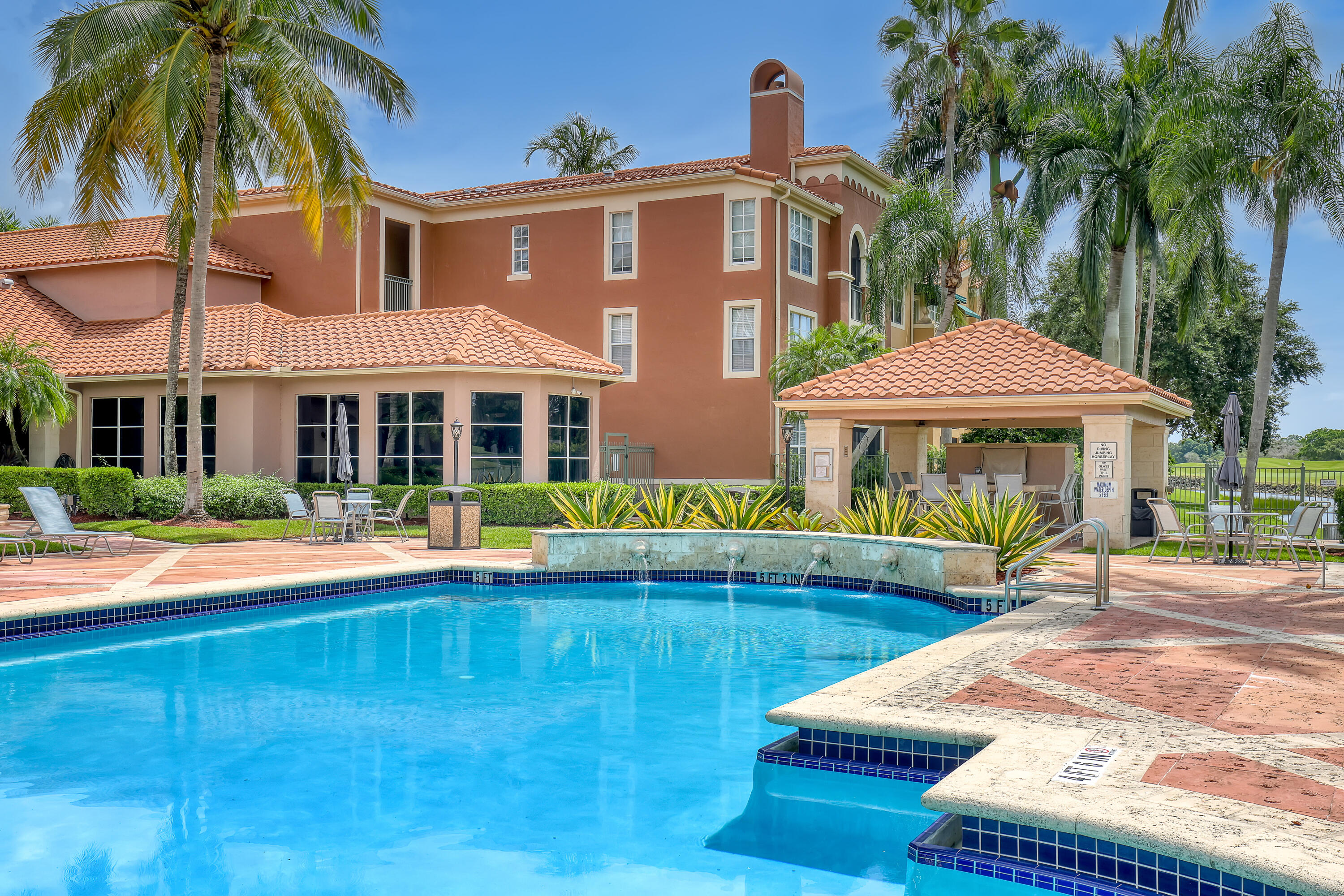 11790 St Andrews Place, Unit 105 Wellington, FL 33414 - Photo 42 of 55 a front view of a house with swimming pool having outdoor seating