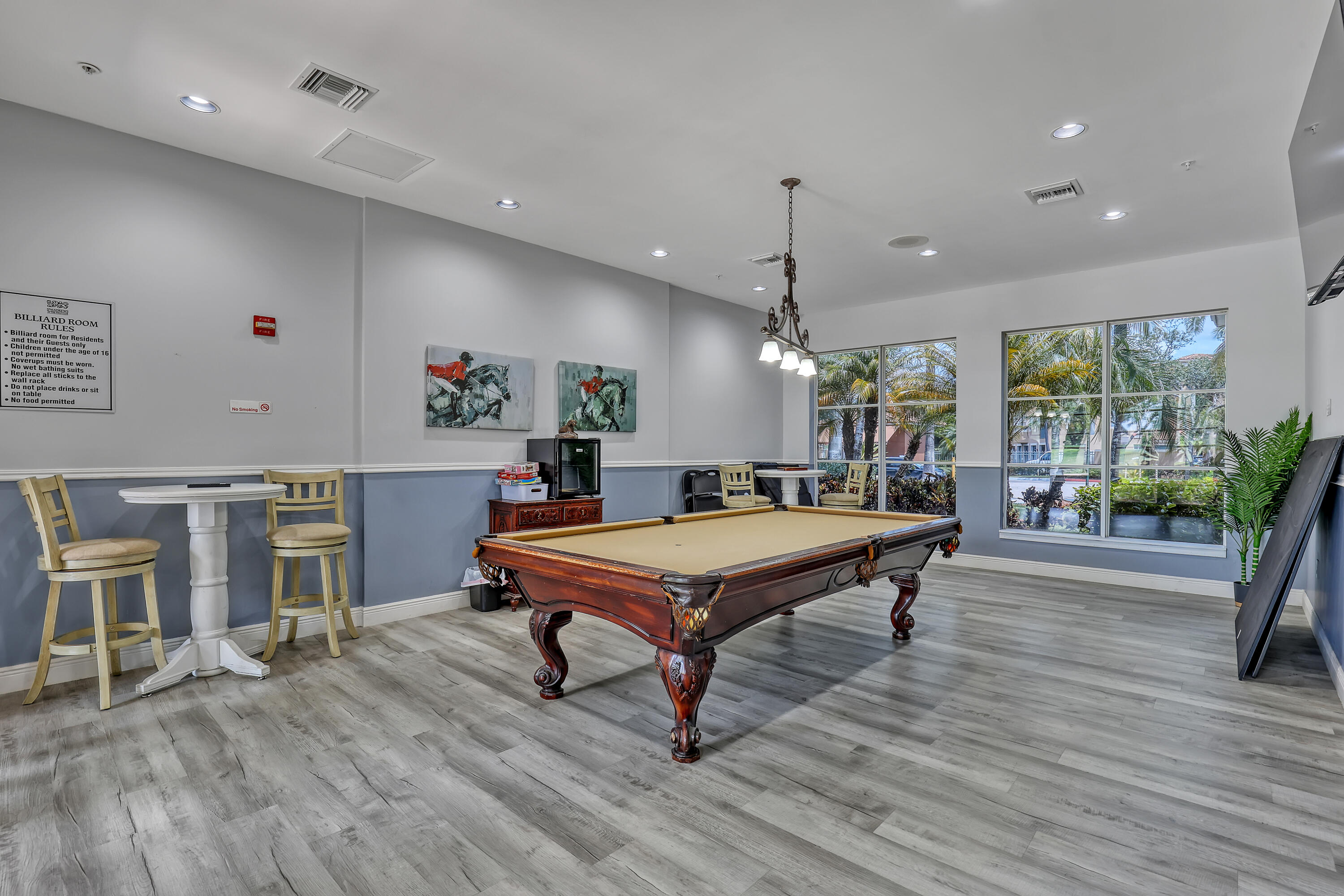 11790 St Andrews Place, Unit 105 Wellington, FL 33414 - Photo 48 of 55 a room with wooden floor pool table and windows
