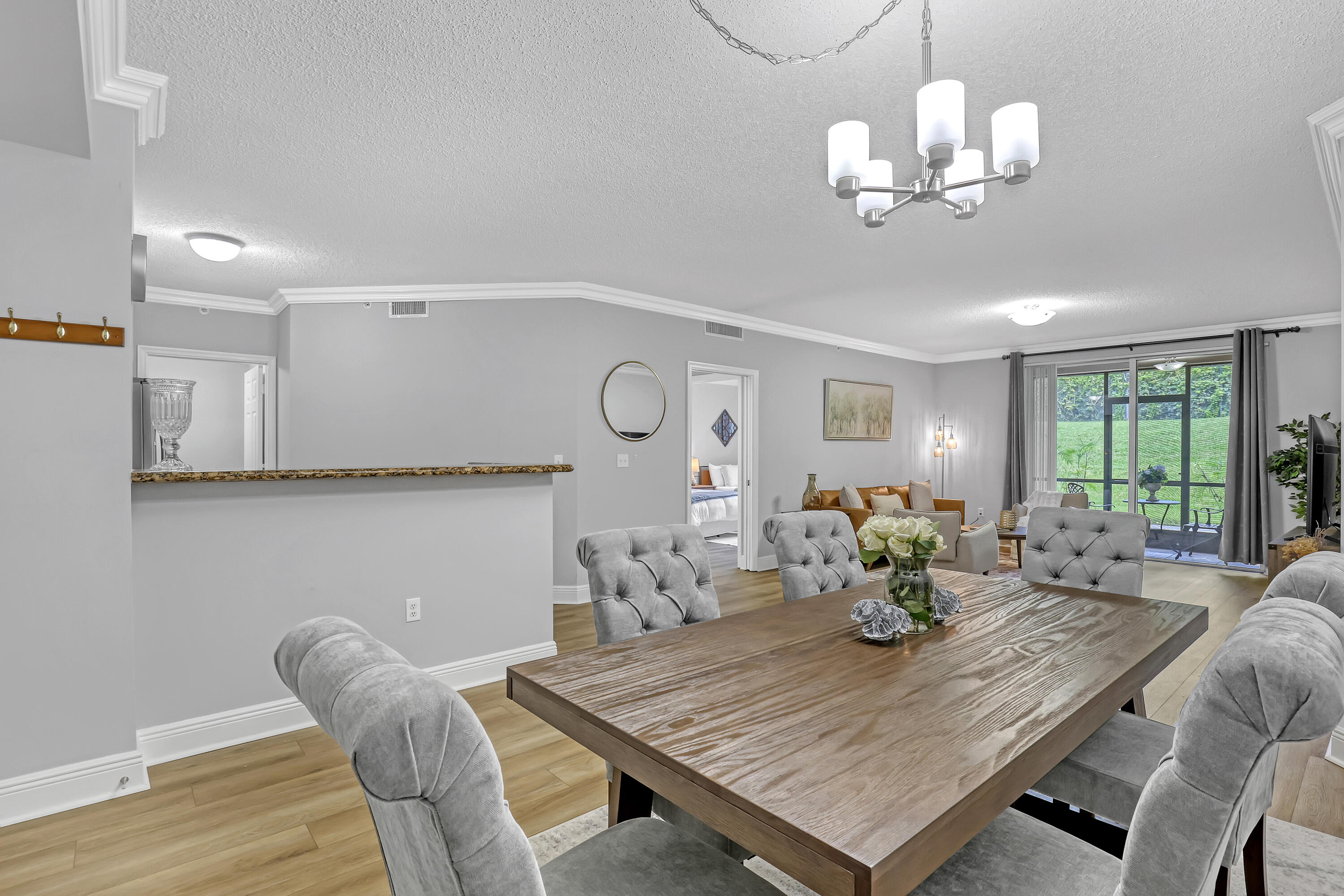 11790 St Andrews Place, Unit 105 Wellington, FL 33414 - Photo 5 of 55 a view of a dining room with furniture a chandelier and wooden floor