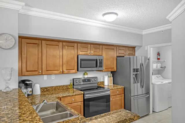 a kitchen with stainless steel appliances granite countertop a stove a sink and a microwave