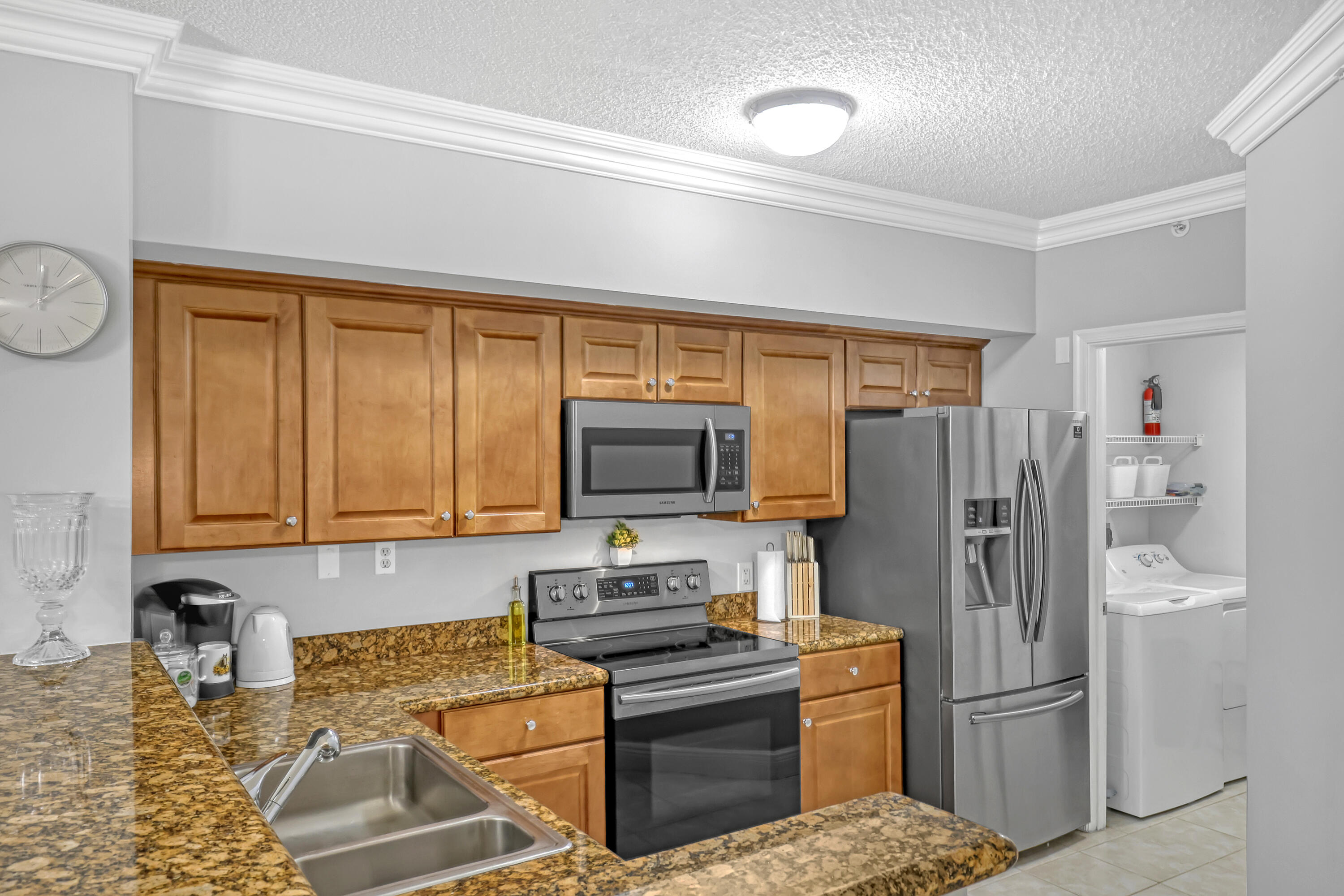 11790 St Andrews Place, Unit 105 Wellington, FL 33414 - Photo 10 of 55 a kitchen with stainless steel appliances granite countertop a refrigerator stove and microwave