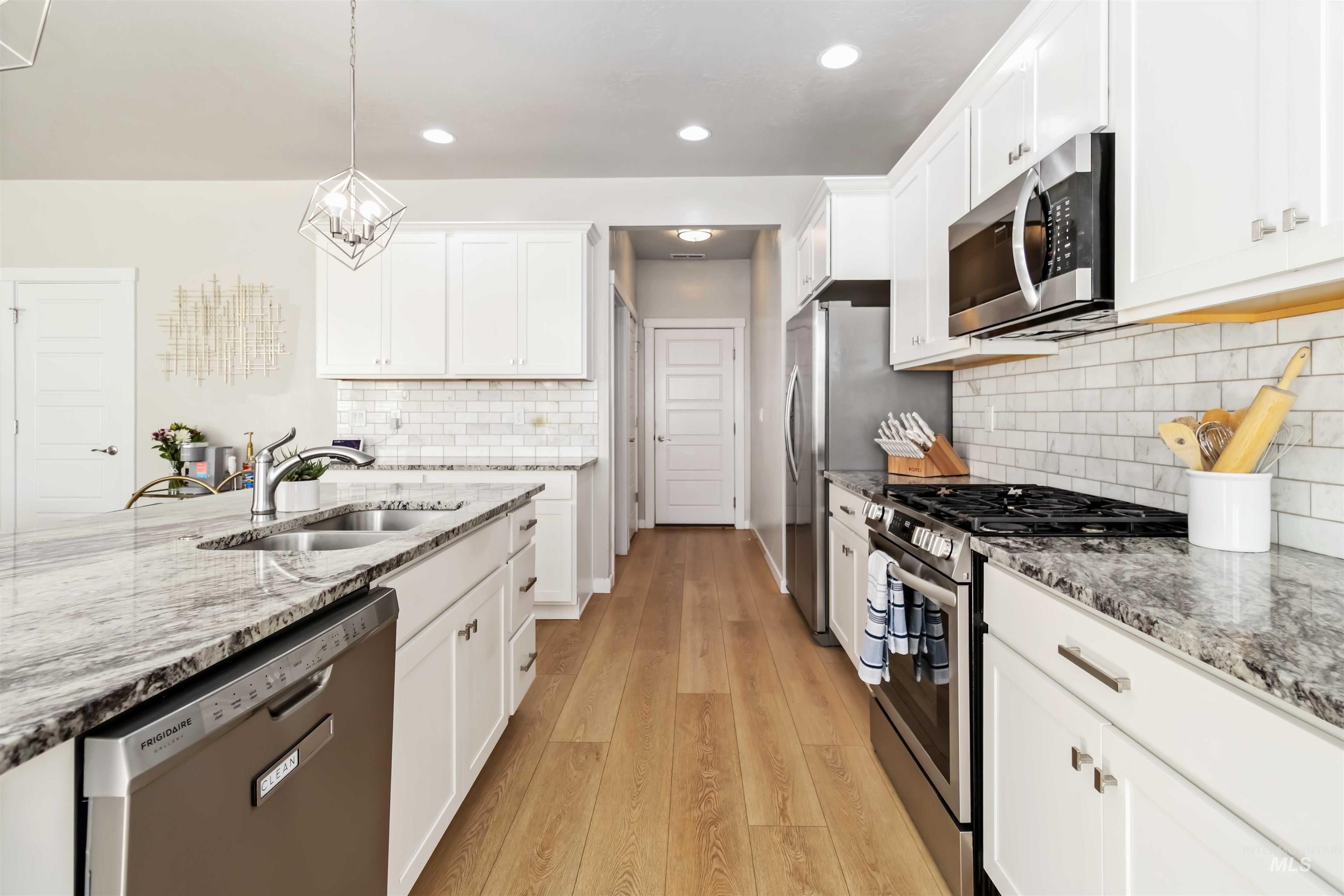 892 North Chastain Lane Eagle, ID 83616 - Photo 11 of 45 Kitchen featuring appliances with stainless steel finishes, light stone counters, white cabinetry, and recessed lighting