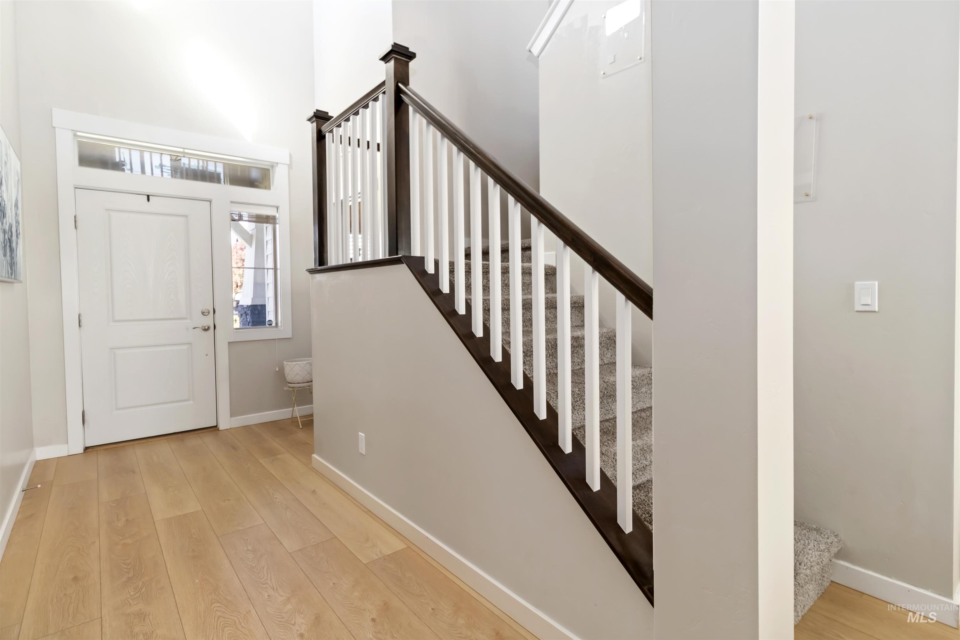 892 North Chastain Lane Eagle, ID 83616 - Photo 25 of 45 Entryway featuring stairs, light wood-style flooring, and a high ceiling