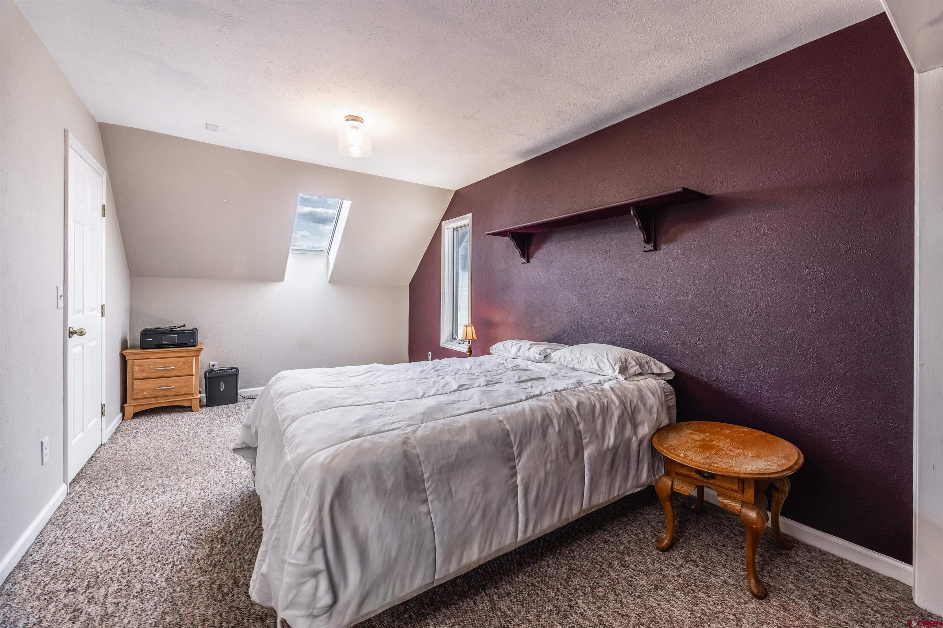 19555 6575th Road Montrose, CO 81403 - Photo 14 of 36 a bedroom with a bed a lamp and a table