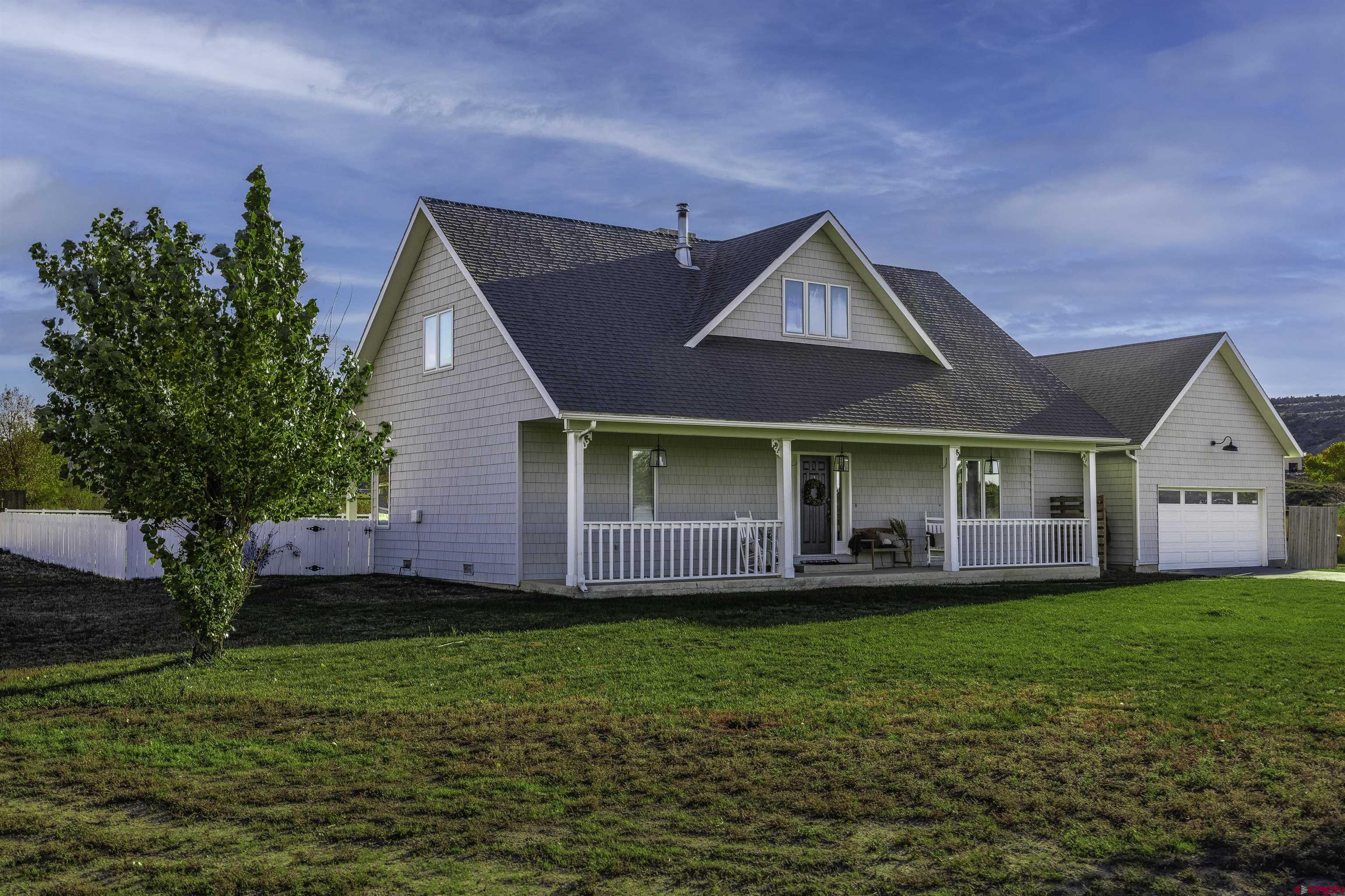 19555 6575th Road Montrose, CO 81403 - Photo 22 of 36 a front view of a house with a yard and potted plants
