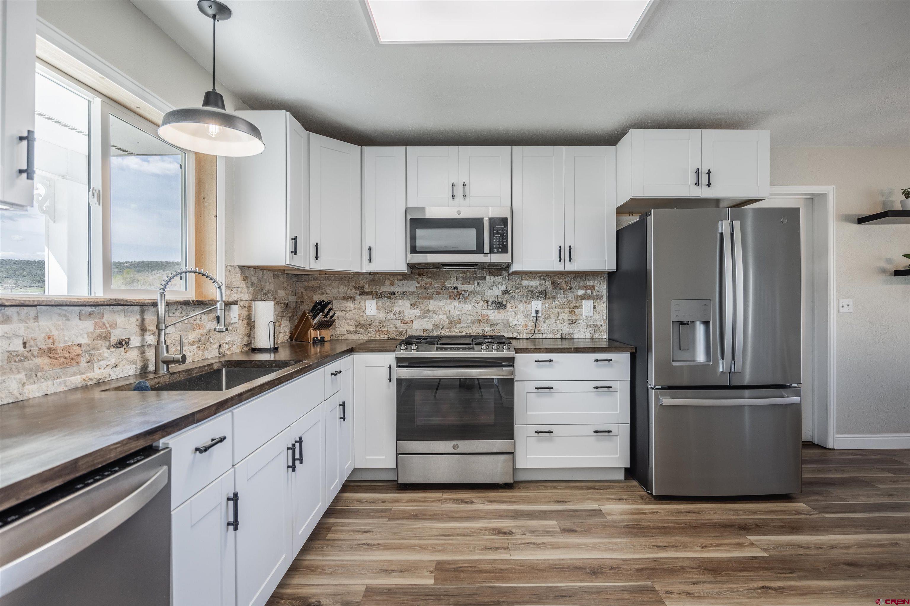 19555 6575th Road Montrose, CO 81403 - Photo 4 of 36 a kitchen with cabinets stainless steel appliances and a window