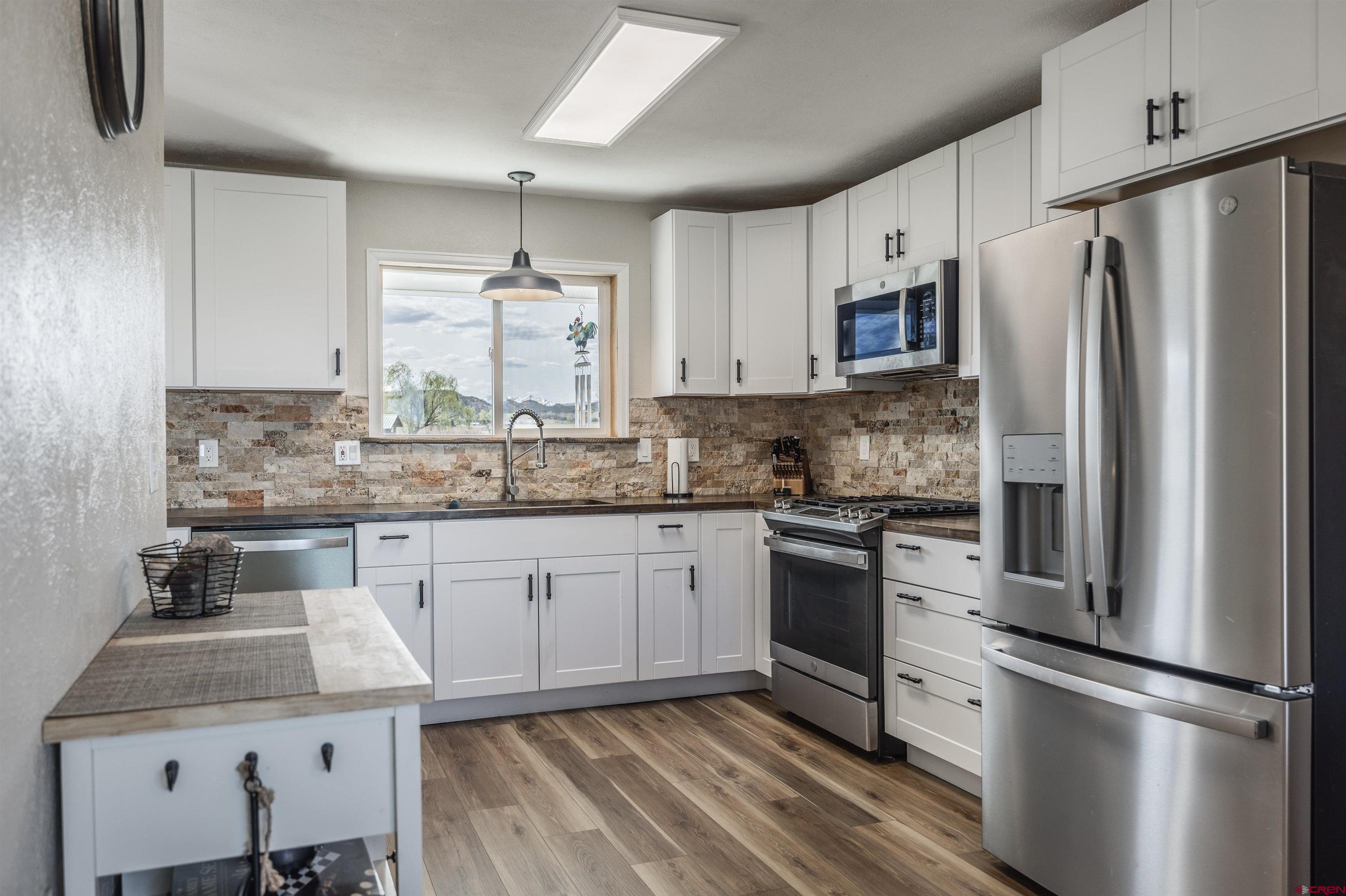 19555 6575th Road Montrose, CO 81403 - Photo 6 of 36 a kitchen with stainless steel appliances granite countertop a sink stove and refrigerator