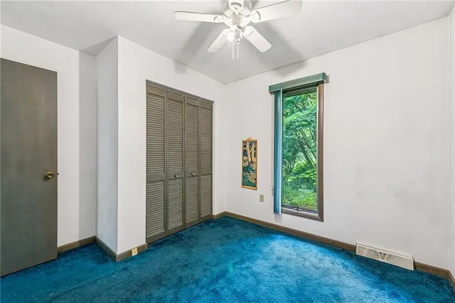 an empty room with fan and windows