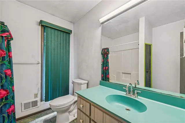 a bathroom with a sink toilet and a mirror