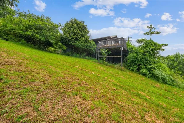 a backyard of a house with table and chairs plants and large trees