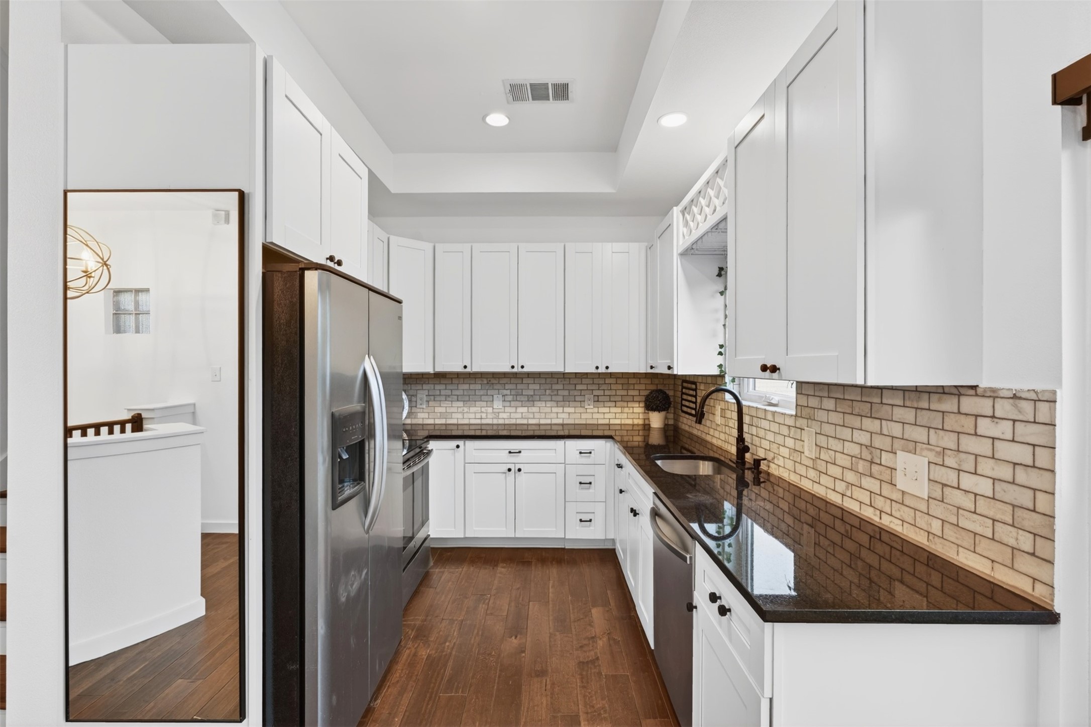 2716 Bagby Street Houston, TX 77006 - Photo 9 of 29 a kitchen with granite countertop a refrigerator a sink a stove and white cabinets
