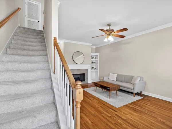 a living room with furniture a fireplace and a ceiling fan