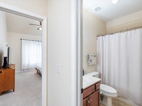 a bathroom with a granite countertop toilet a sink and a mirror