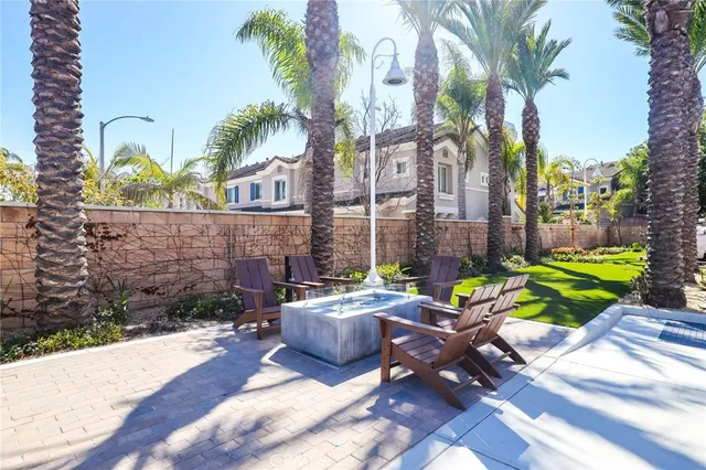 a view of a patio with table and chairs potted plants and palm tree