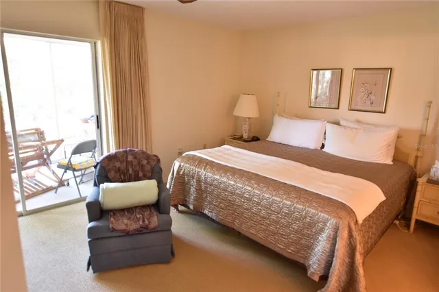 a bedroom with a bed couch and a large window