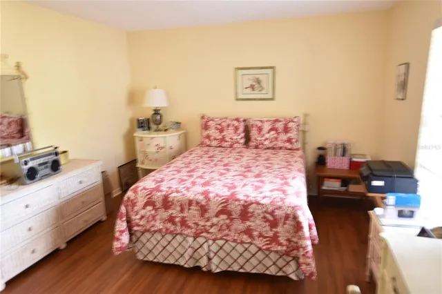 a bed sitting in a bedroom next to a window with wooden floor