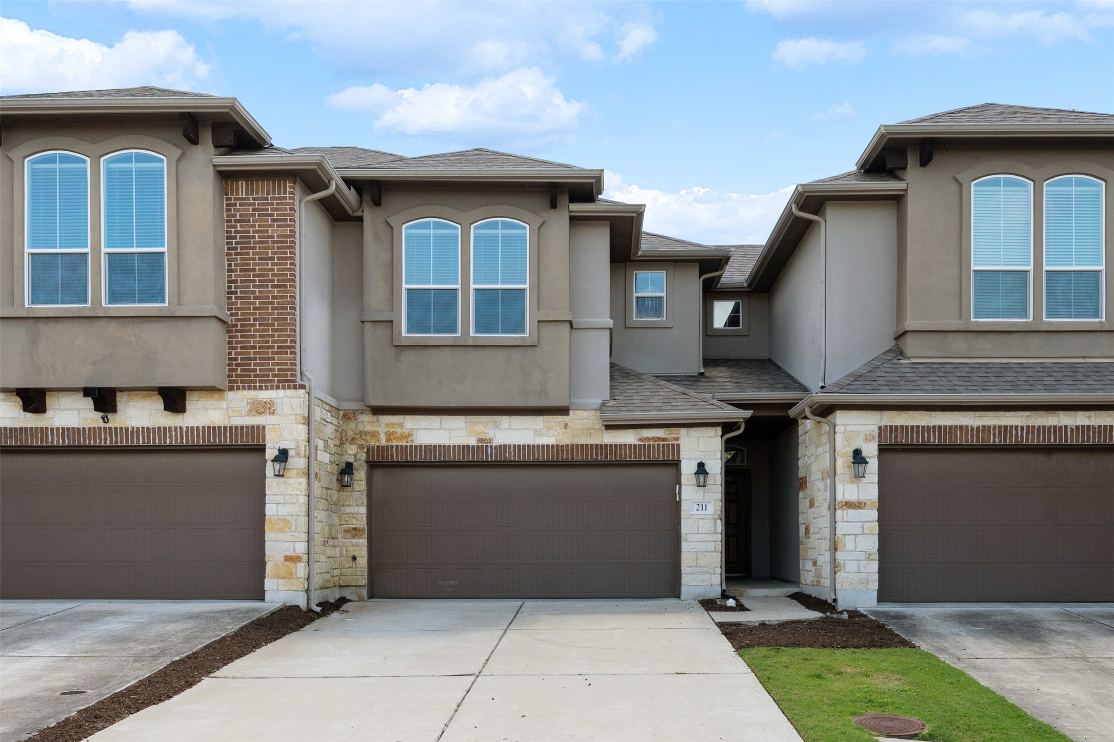 211 Parable Cove Pflugerville, TX 78660 - Photo 2 of 40 Contemporary stucco and stone facade featuring arched windows