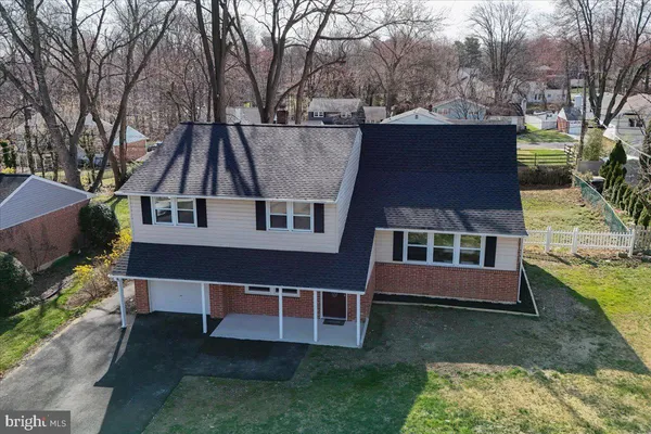 a aerial view of a house with swimming pool next to a large trees