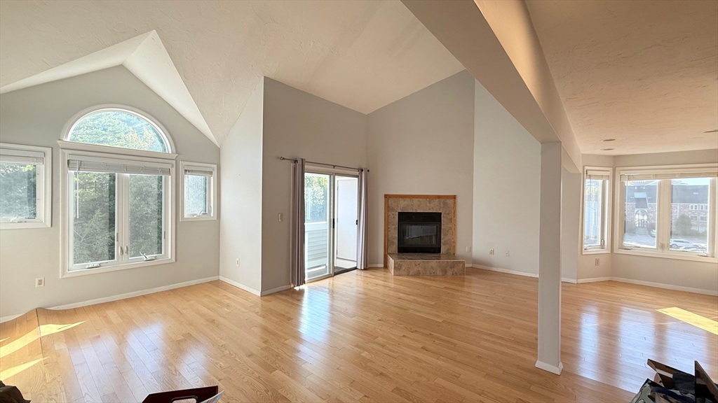 114 Burkhall Street, Unit R Weymouth, MA 02190 - Photo 1 of 15 an empty room with wooden floor fireplace and windows