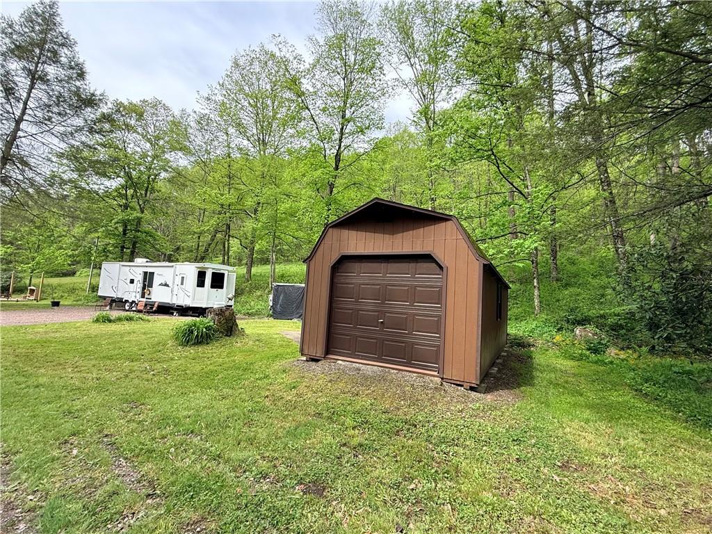321 Dark Hollow Road Confluence, PA 15424 - Photo 3 of 18 a backyard of a house with a garden and barbeque oven