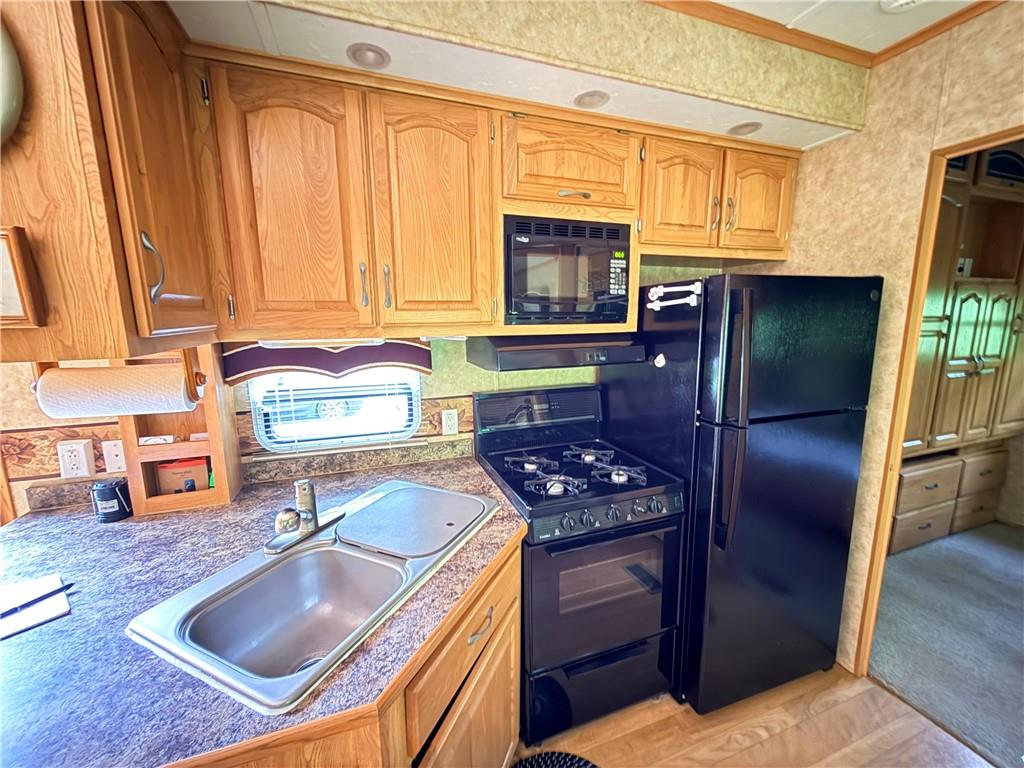 321 Dark Hollow Road Confluence, PA 15424 - Photo 9 of 18 a kitchen with stainless steel appliances granite countertop a refrigerator a stove a sink and dishwasher with a dining table