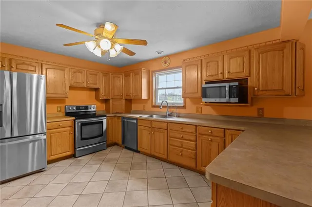 a kitchen with stainless steel appliances granite countertop a refrigerator a stove and a sink