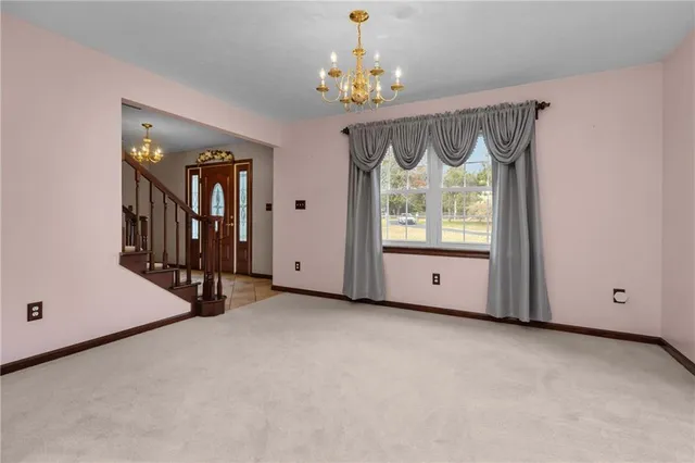 an empty room with windows and chandelier fan